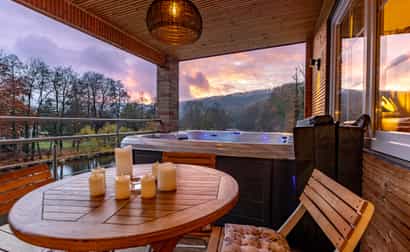 1091185 Jacuzzi auf einer Terrasse bei Sonnenuntergang mit Blick auf einen Fluss