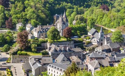 Weiter Blick von oben auf Durbuy mit grünen Bäumen und mittelalterlichen Gebäuden