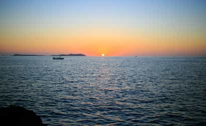 Stimmungsvoller Sonnenuntergang über dem Meer auf Ibiza, goldene Lichtreflexe auf dem Wasser