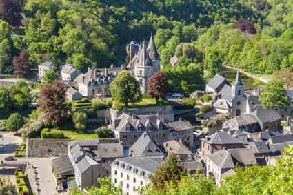 Weiter Blick von oben auf Durbuy mit grünen Bäumen und mittelalterlichen Gebäuden