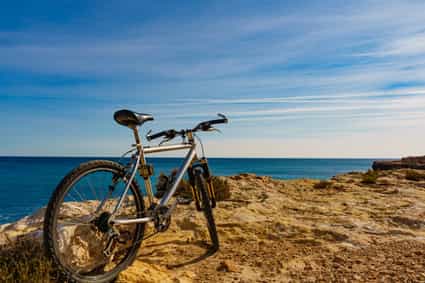 Fahrrad auf einem Felsen mit Blick auf das Meer an der Küste