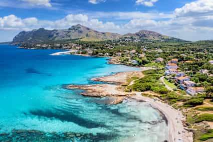 Luftaufnahme der Platja de Sant Pere bei Alcúdia auf Mallorca mit Strand und türkisfarbenem Wasser