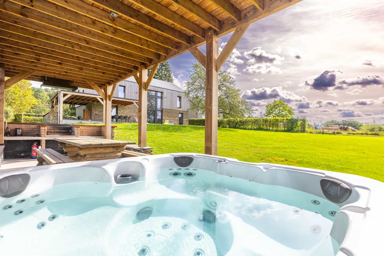 Blick vom Jacuzzi eines Chalets in Lierneux auf eine Wiese, Wellness und Entspannung