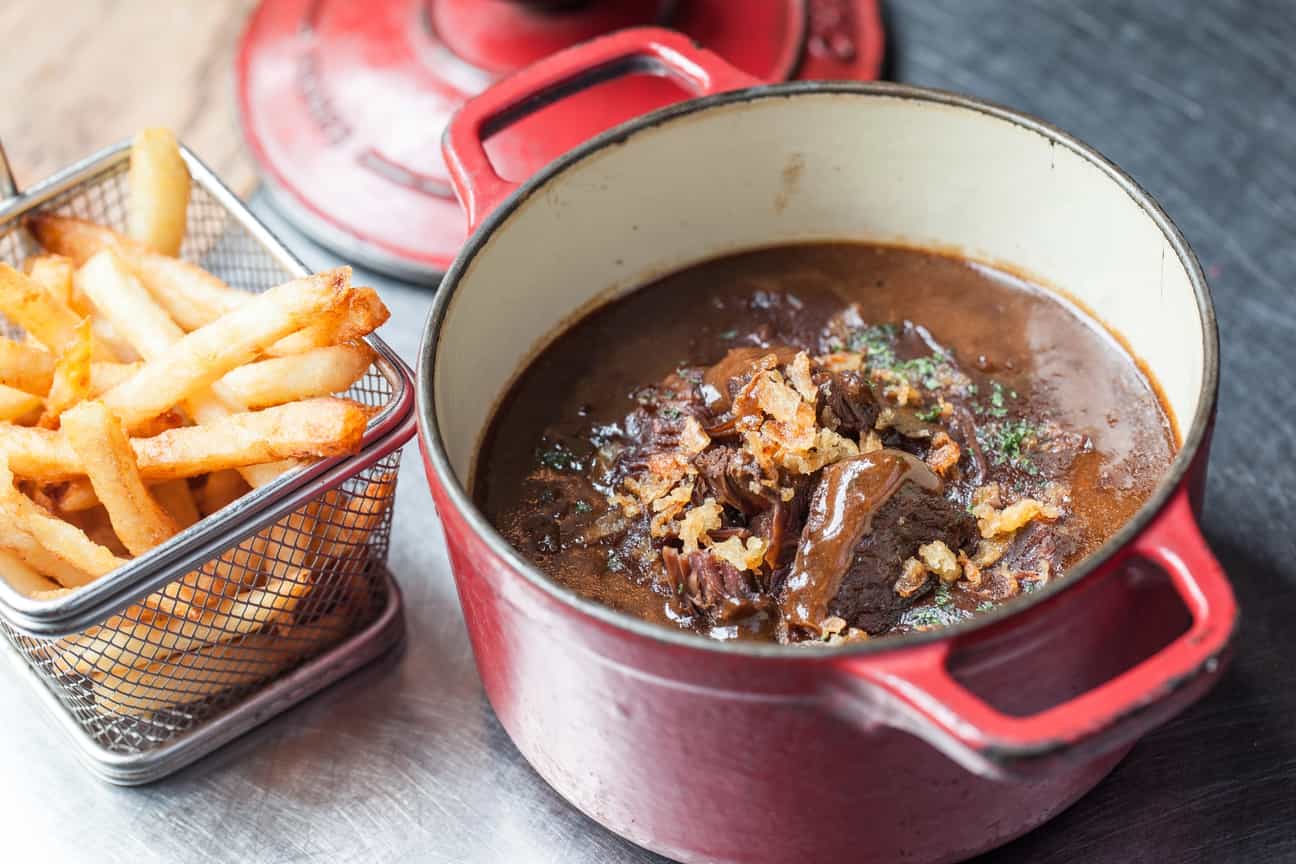 Nahaufnahme von belgischem Stoofvlees mit goldbraunen Fritten – traditionelles Nationalgericht aus Belgien.