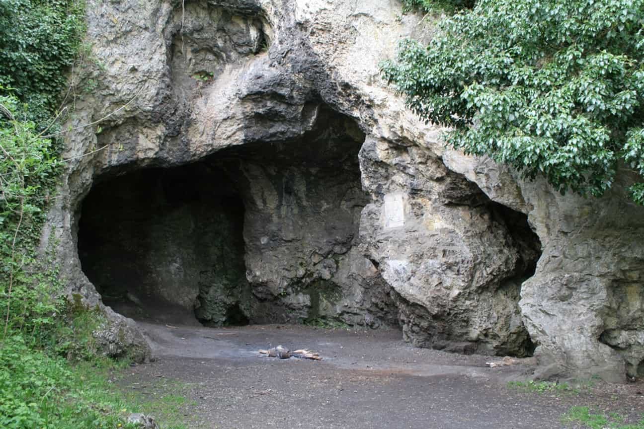 Eingang der Grotte de Spy mit Felsen und grüner Umgebung, eine prähistorisch bedeutende Höhle