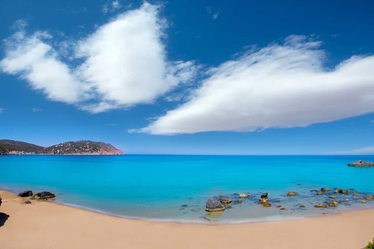 Strand Aigües Blanques bei Santa Eulària des Riu mit blauem Mittelmeer und felsiger Küstenlandschaft auf Ibiza