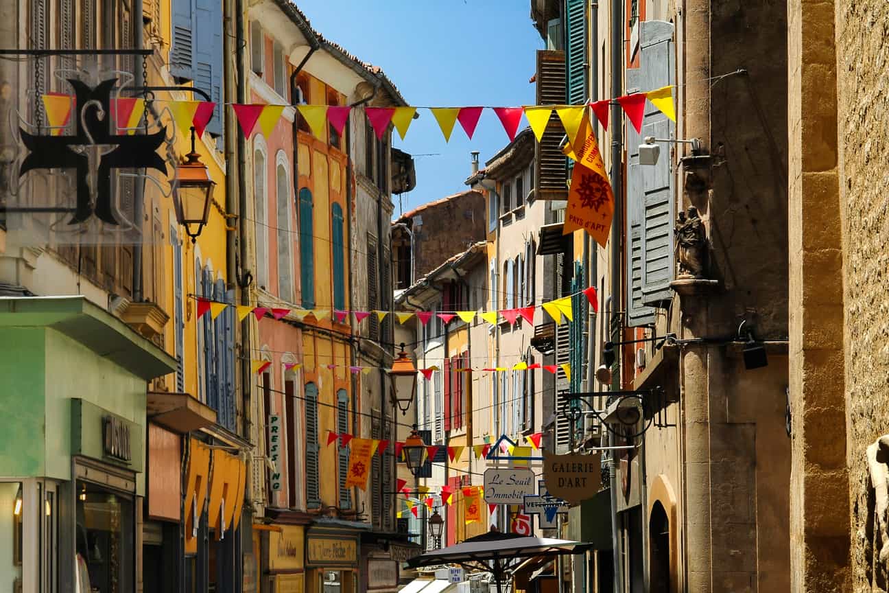 Historische Gebäude und bunte Wimpel in den Gassen von Apt im Vaucluse, Provence, Frankreich