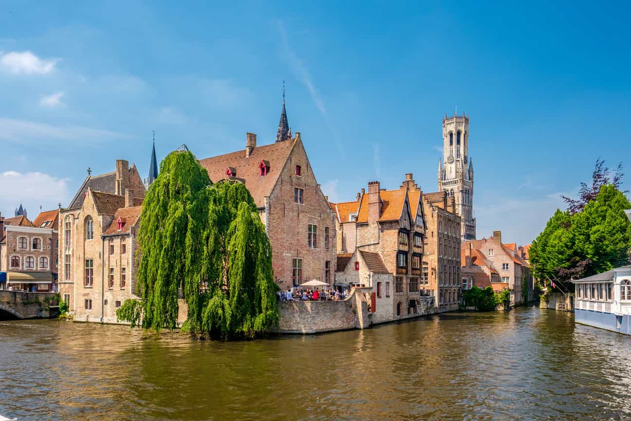 Blick auf die historische Altstadt von Brügge vom Kanal aus, mit markantem Turm im Hintergrund