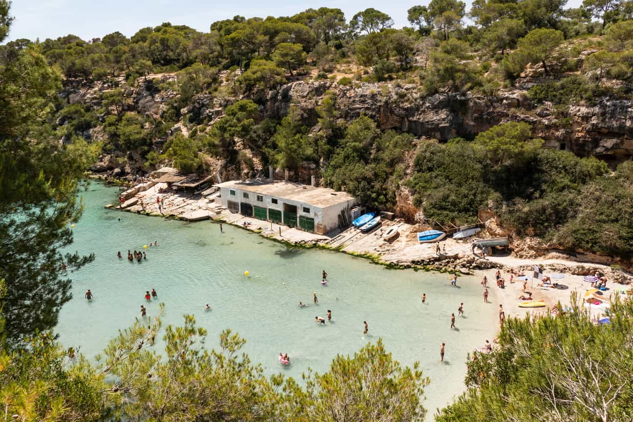 Strand Cala Pi auf Mallorca mit Sandstrand, türkisfarbenem Wasser und umgebenden Felsen