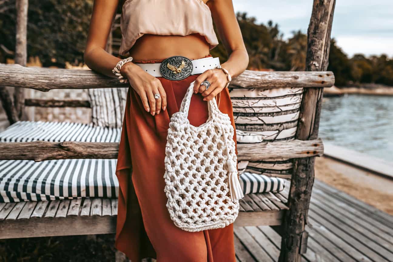 Frau mit typisch ibizianischer Stofftasche im Boho-Stil, gewebt aus Naturmaterialien