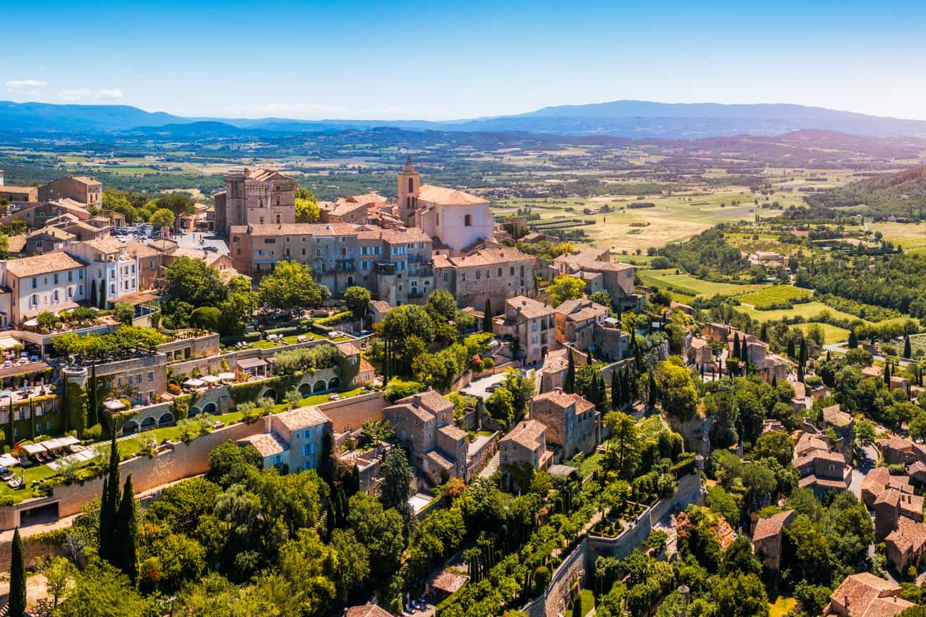 Panoramablick auf Gordes in der Provence, Dorf auf einem Hügel mit weiter Landschaft im Hintergrund