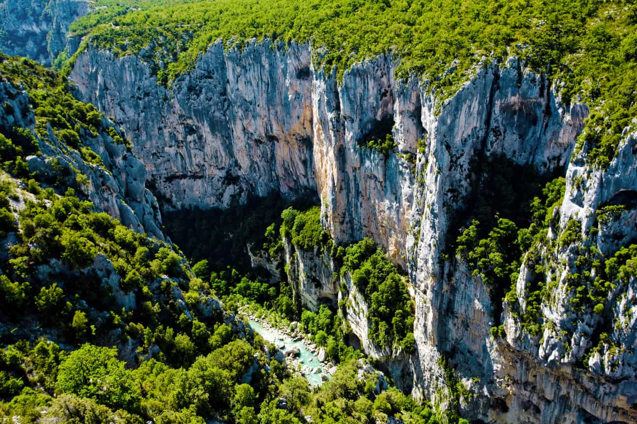 Luftbild der Verdon-Schlucht mit türkisfarbenem Fluss, umgeben von steilen Felswänden und bewaldeten Hängen