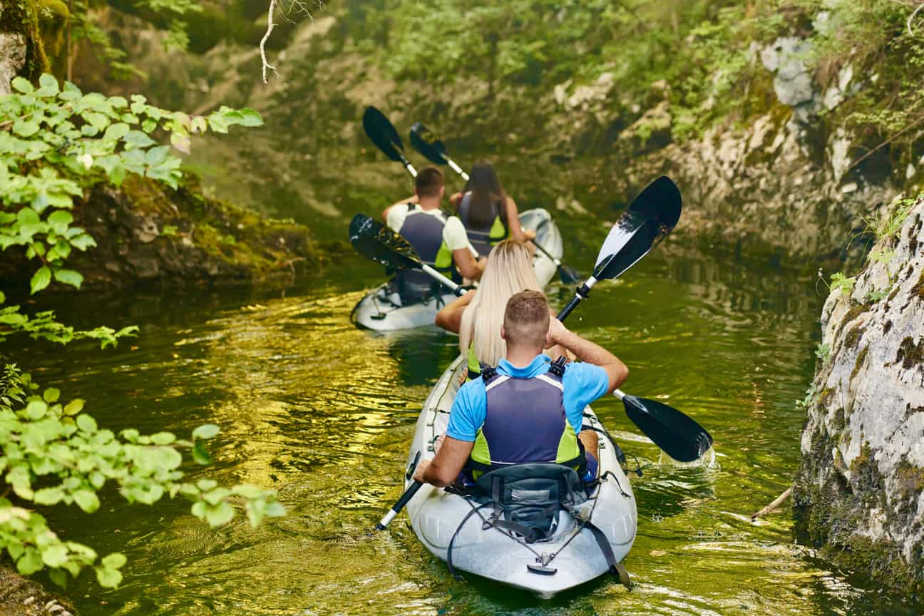 Kajakfahrer auf der Ourthe inmitten der bewaldeten Landschaft der Ardennen