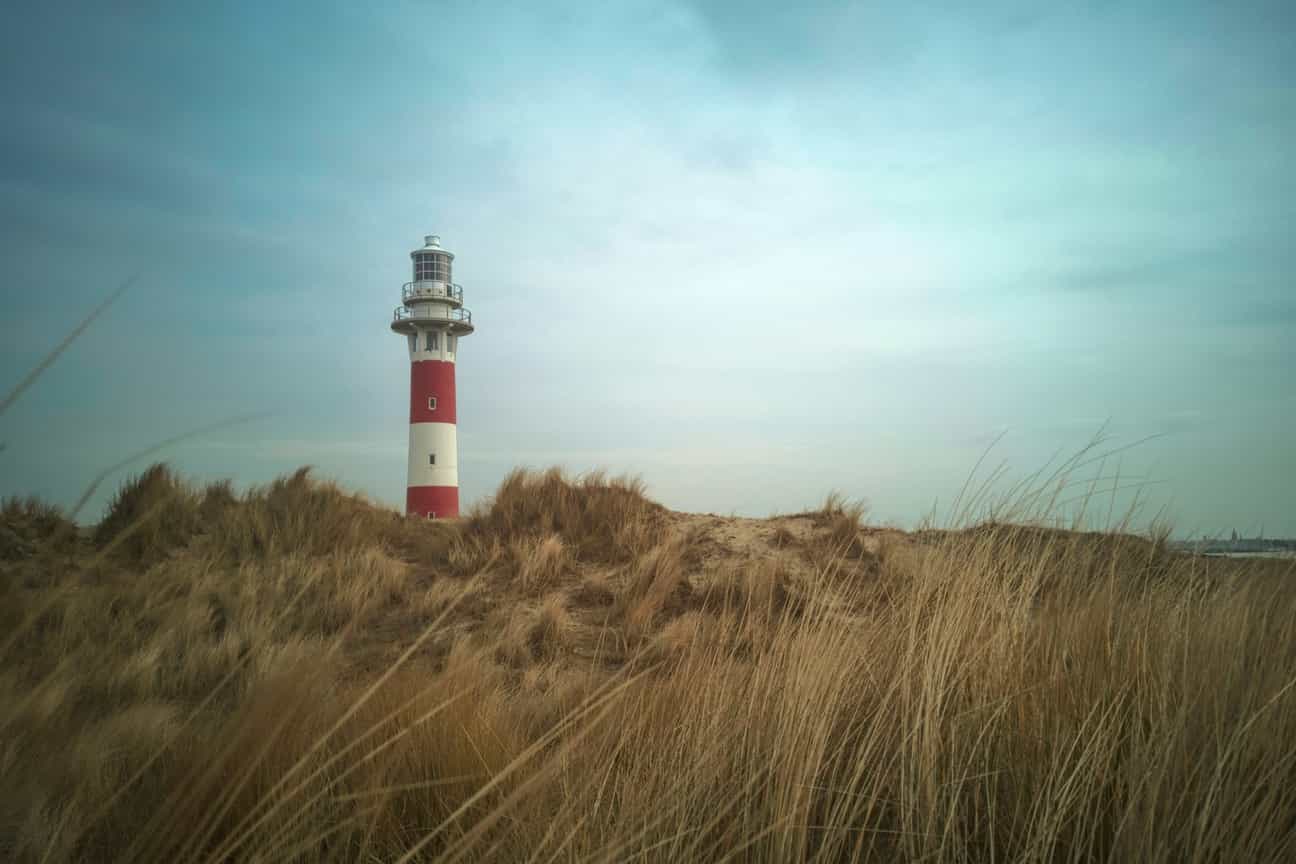 Leuchtturm von Nieuwpoort an der belgischen Nordseeküste, aufgenommen bei Tageslicht mit blauem Himmel im Hintergrund