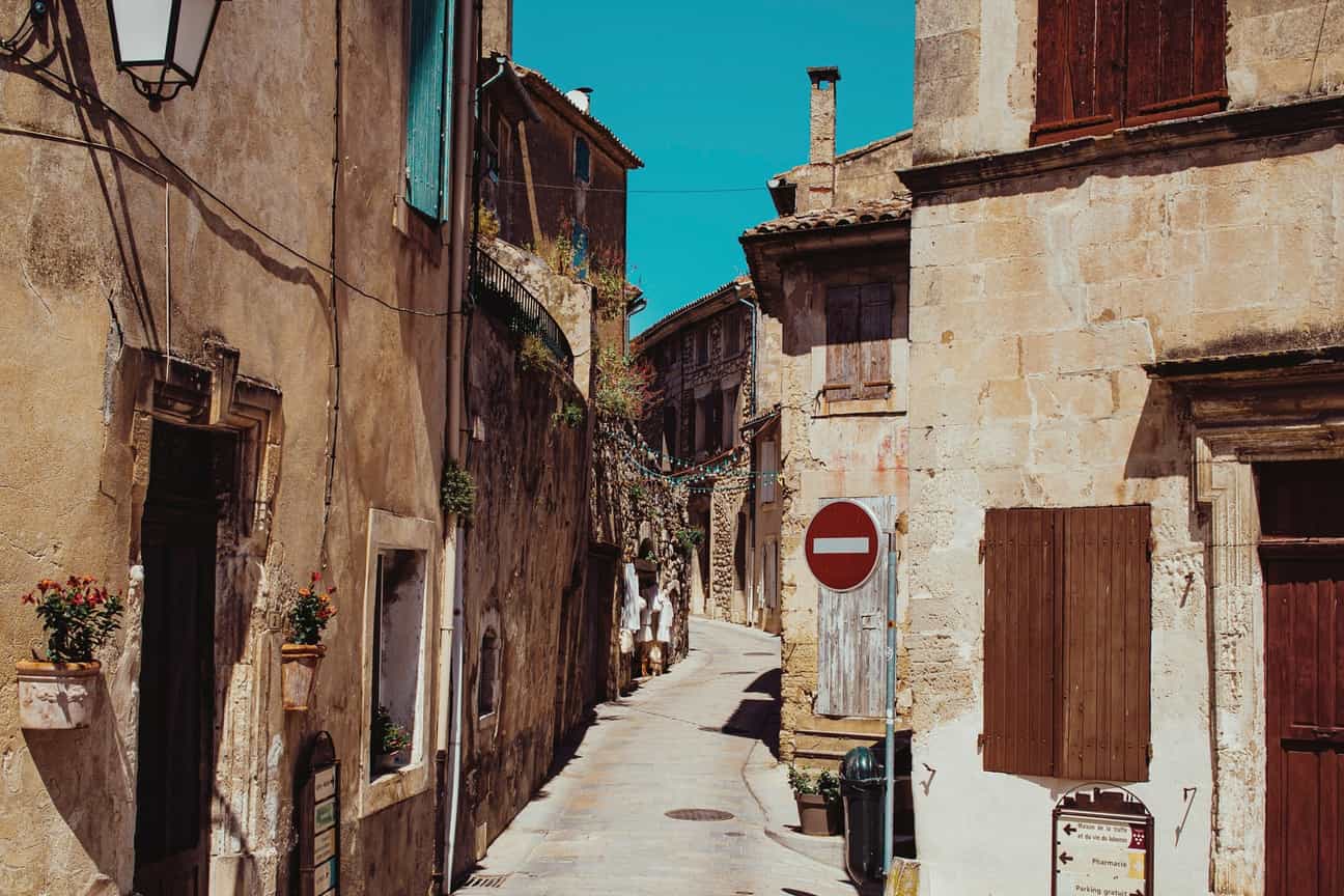 Blick in eine schmale Gasse von Ménerbes mit Natursteinmauern und mediterranem Flair in der Provence