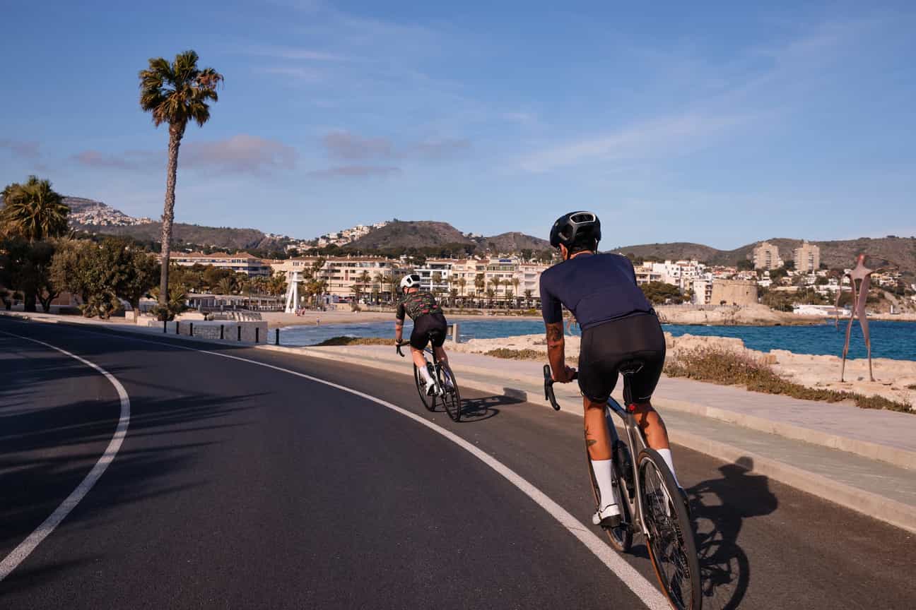 Rennradfahrer auf einer Küstenstraße auf Mallorca mit Meerblick und mediterraner Landschaft