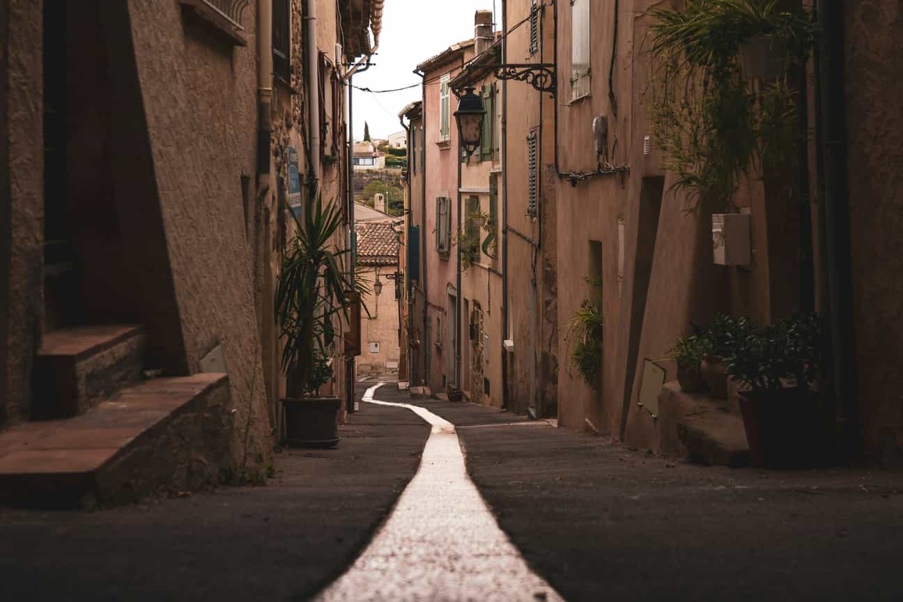 Schmale, verwinkelte Gasse in Roquebrune-sur-Argens mit Natursteinmauern und mediterranem Charme