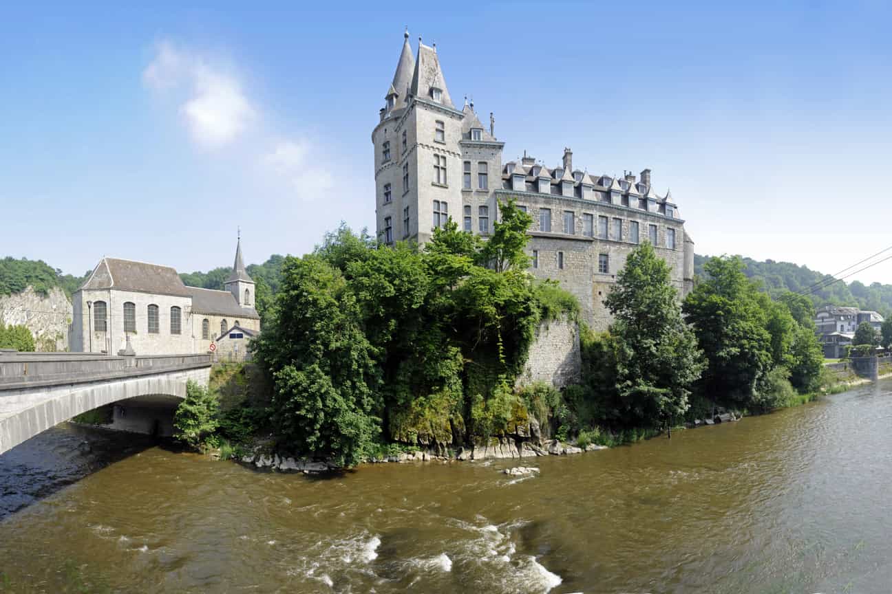 Schloss von Durbuy an einem sonnigen Tag mit Fluss im Vordergrund