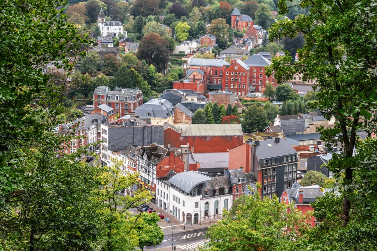 Spa in Belgien ist weltweit für seine Thermalquellen bekannt. Die Luftaufnahme zeigt die historische Kurstadt umgeben von den bewaldeten Hügeln der Ardennen.