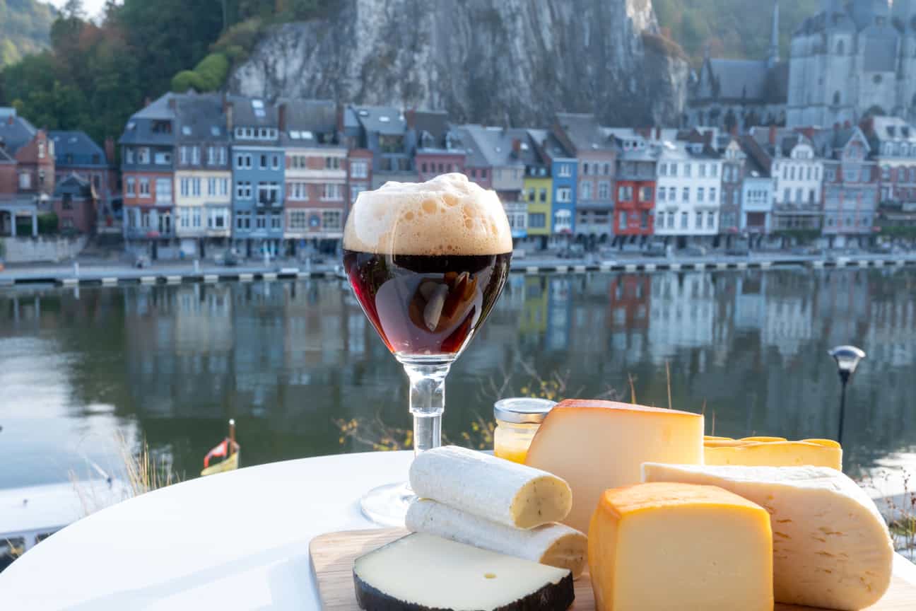Trappistenbier am Flussufer in Dinant mit Blick auf Wasser und Stadt