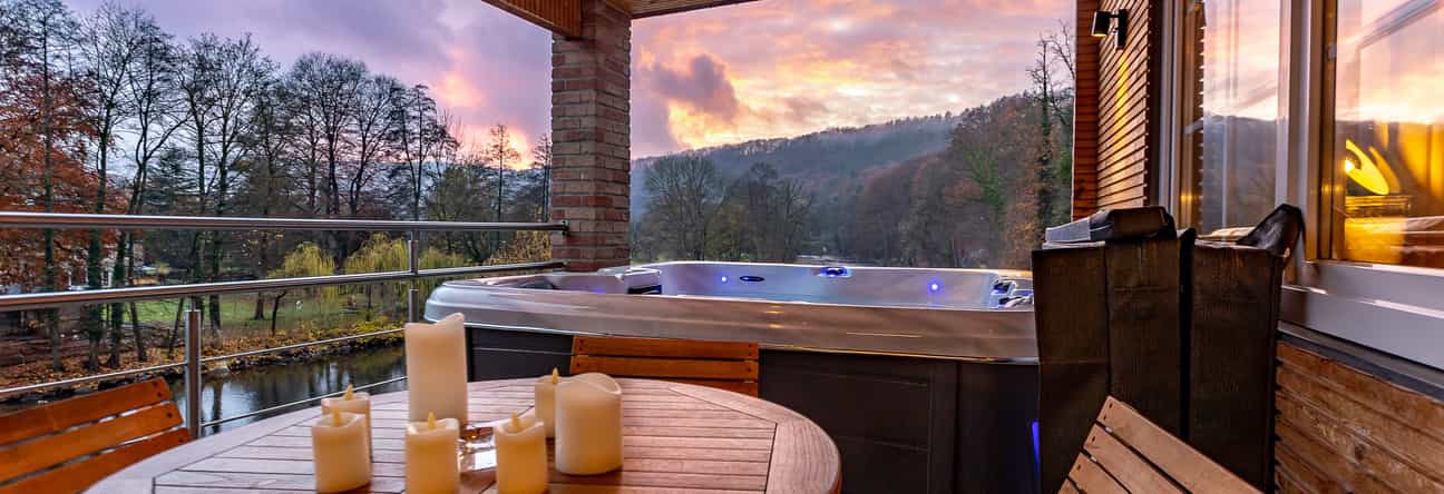 1091185 Jacuzzi auf einer Terrasse bei Sonnenuntergang mit Blick auf einen Fluss
