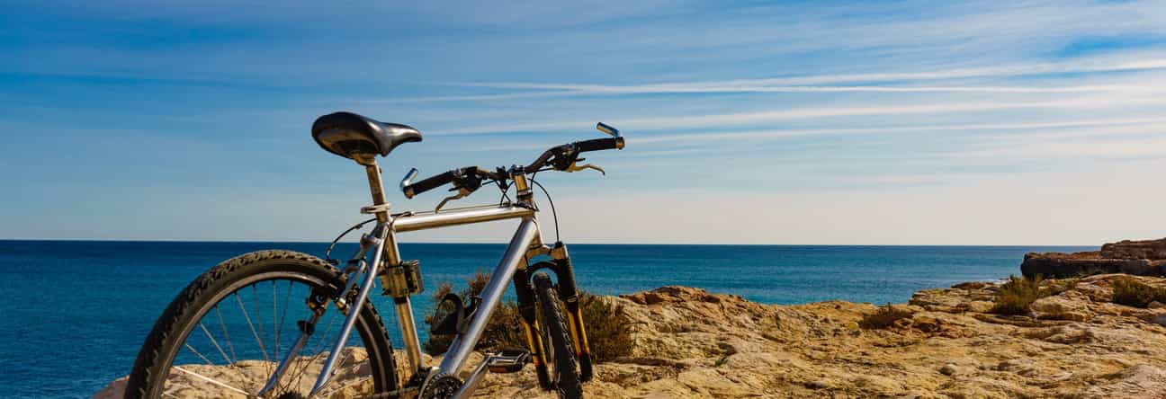 Fahrrad auf einem Felsen mit Blick auf das Meer an der Küste