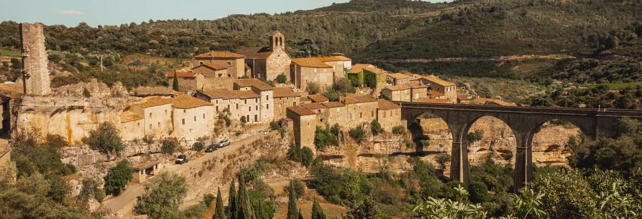 Weitwinkelansicht über das mittelalterliche Dorf Minerve mit seinen alten Steinhäusern und der umgebenden Schluchtenlandschaft in Südfrankreich