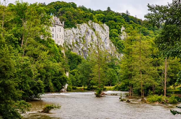 Kajakfahrer auf der Lesse bei Schloss Walzin in den Ardennen, umgeben von Felsen und Wald